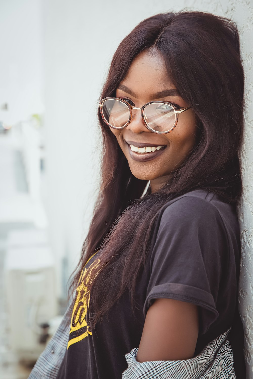 woman smiling and leaning on wall