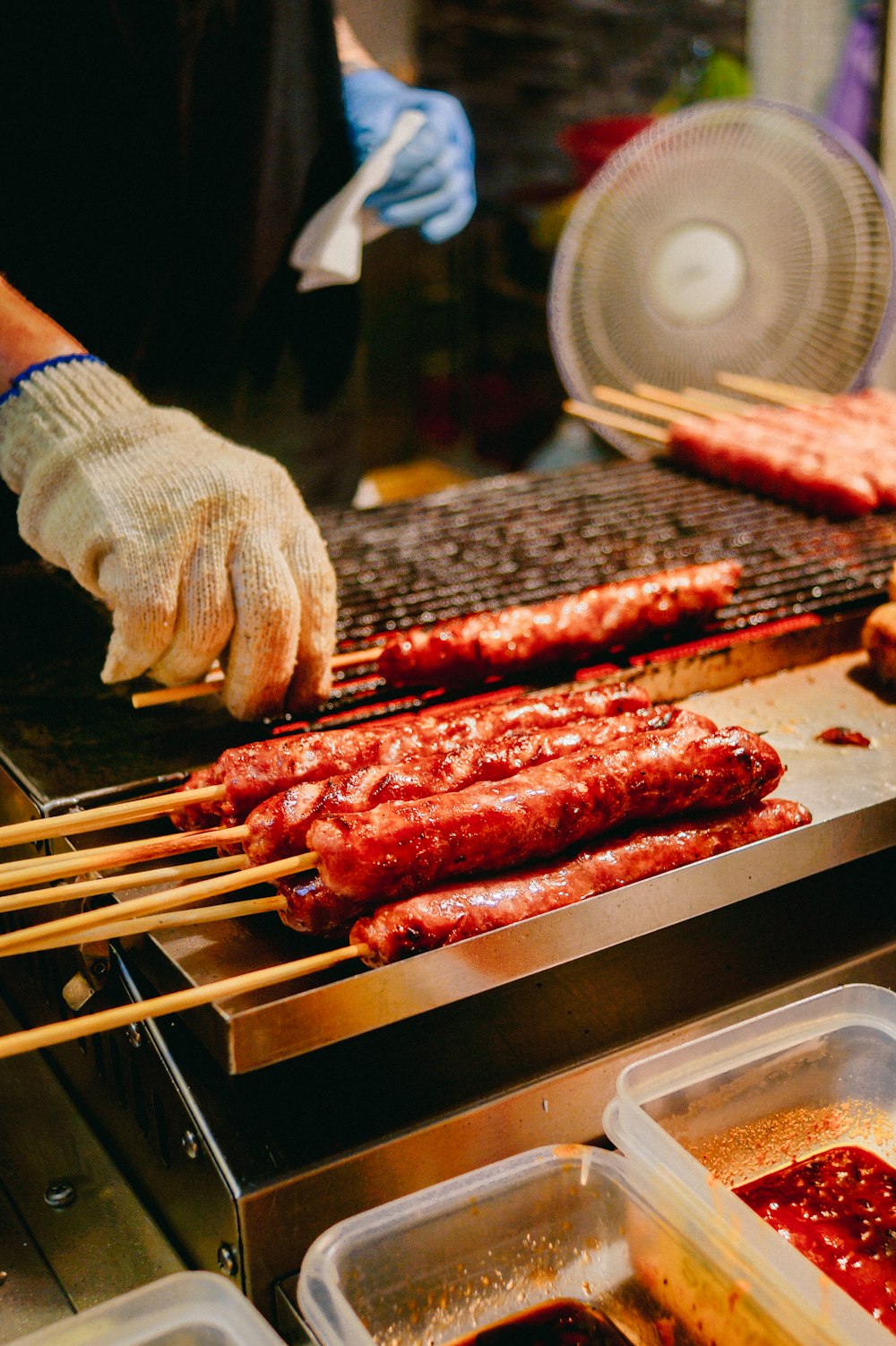 persona asando perritos calientes a la parrilla