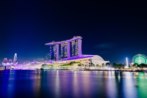 A vibrant night view of a luxury island with illuminated casinos and entertainment venues.