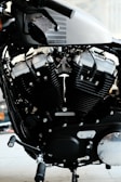 A detailed view of a motorcycle engine, showcasing the intricate design and engineering. The Harley-Davidson branding is visible on the metallic body, with prominent black and silver components.