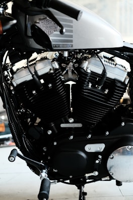 A detailed view of a motorcycle engine, showcasing the intricate design and engineering. The Harley-Davidson branding is visible on the metallic body, with prominent black and silver components.