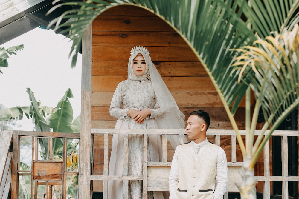 newly wed couple sitting and standing on terrace