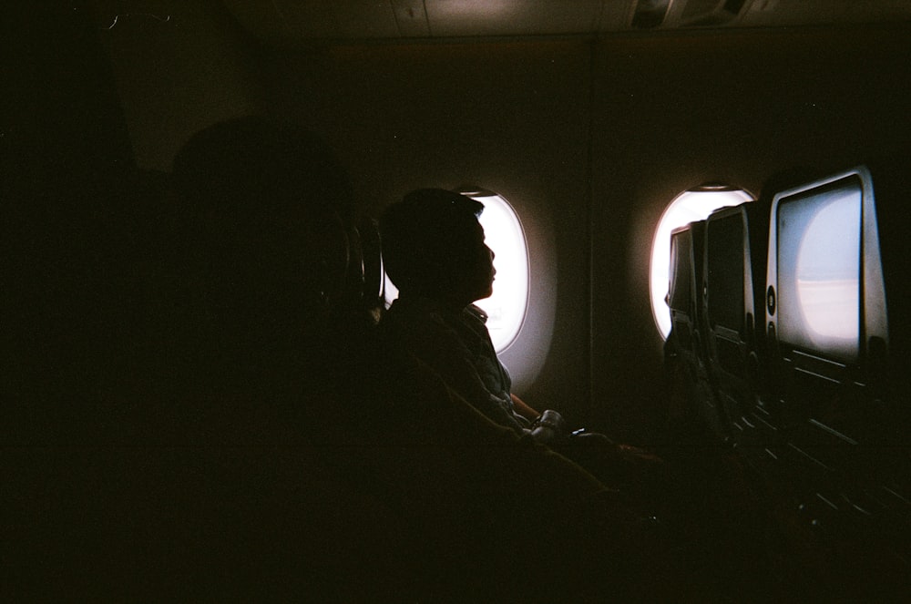 man sitting beside air plane mirror