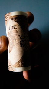 Close-up of hands exchanging currency notes in a financial transaction.