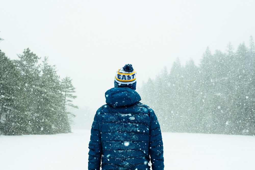 person in blue jacket standing on snow-covered ground