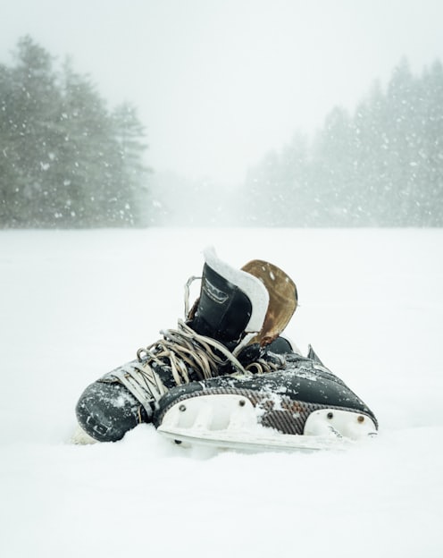 pair of black-and-white ice skates surrounded by snow