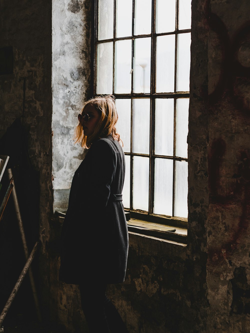 woman standing near closed window inside room