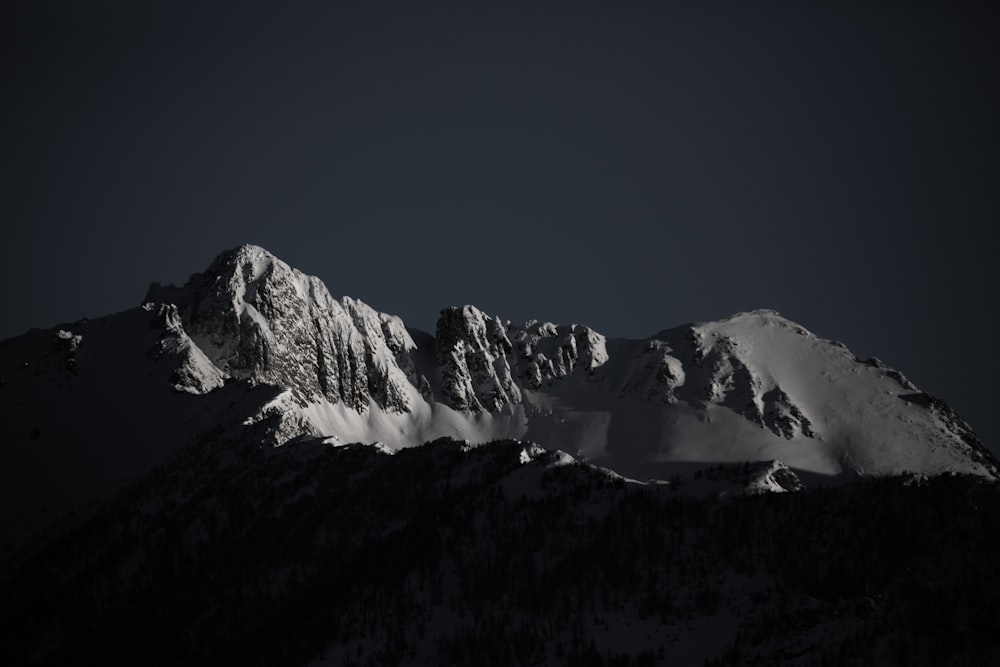 fotografia em tons de cinza da montanha de neve