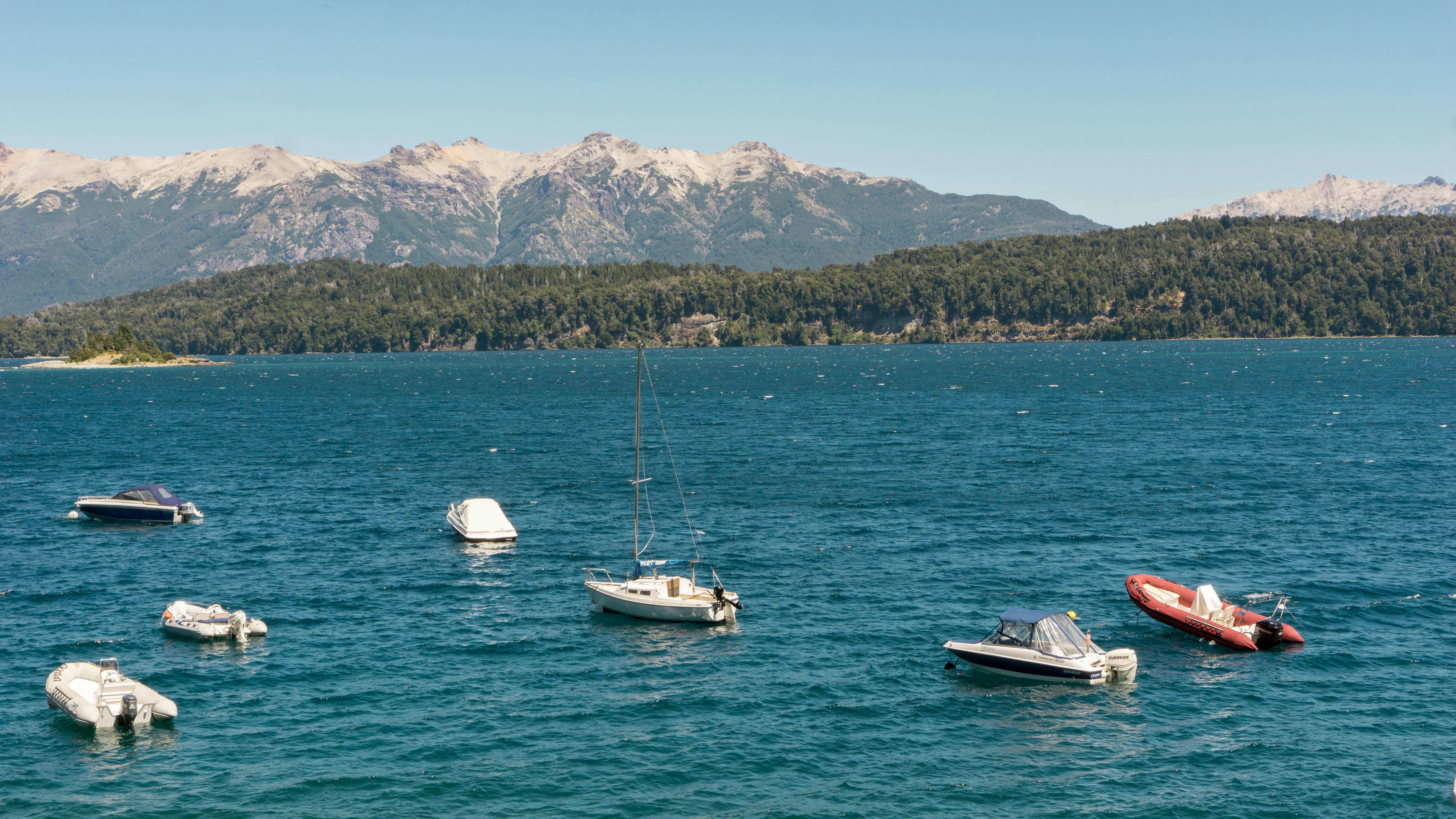 speedboat and motorboat on body of water during daytime