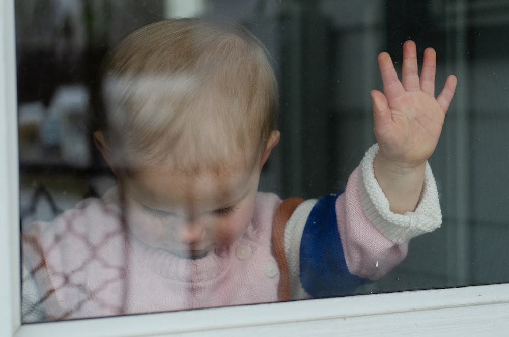 child behind clear glass