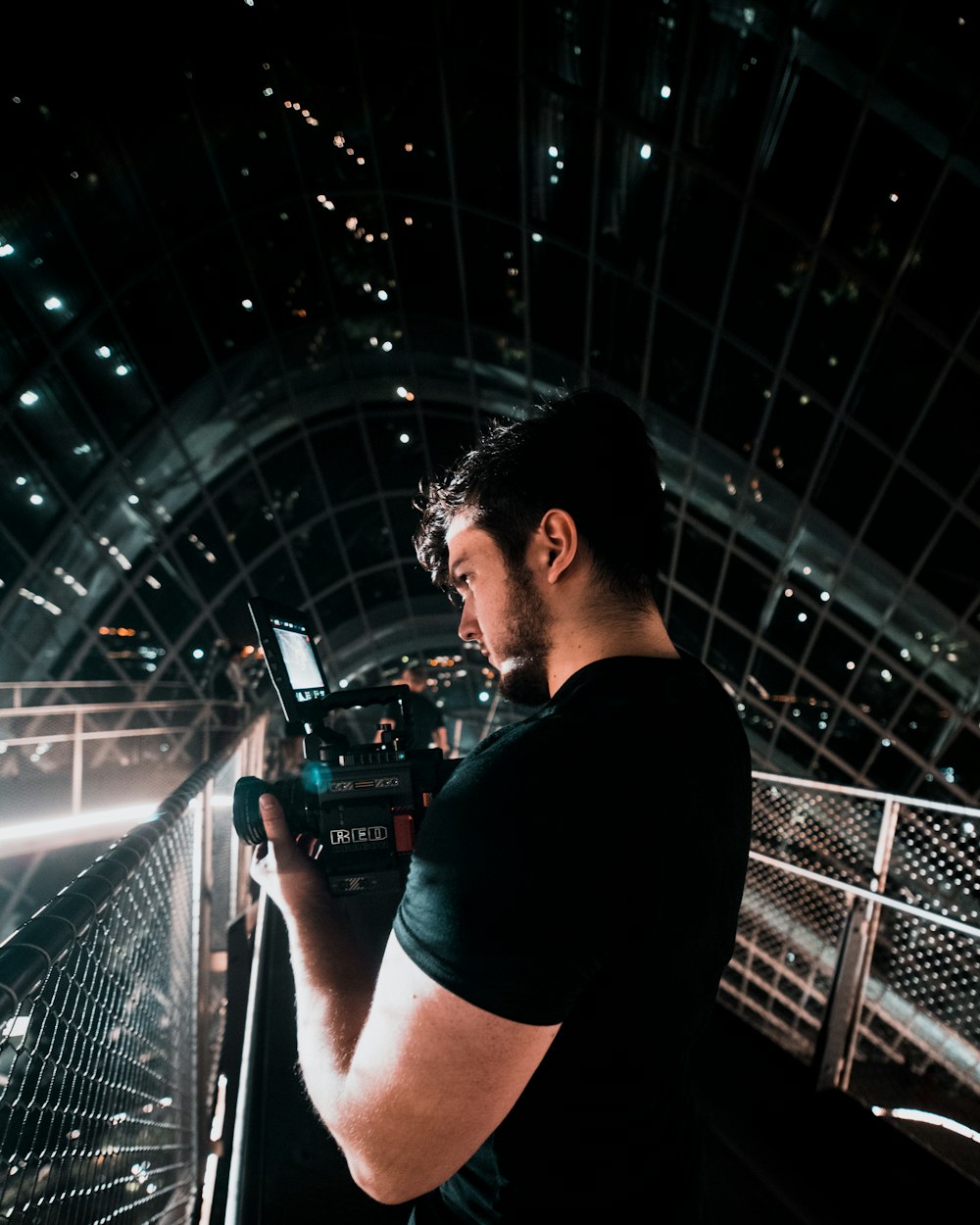 man wearing black shirt holding video camera
