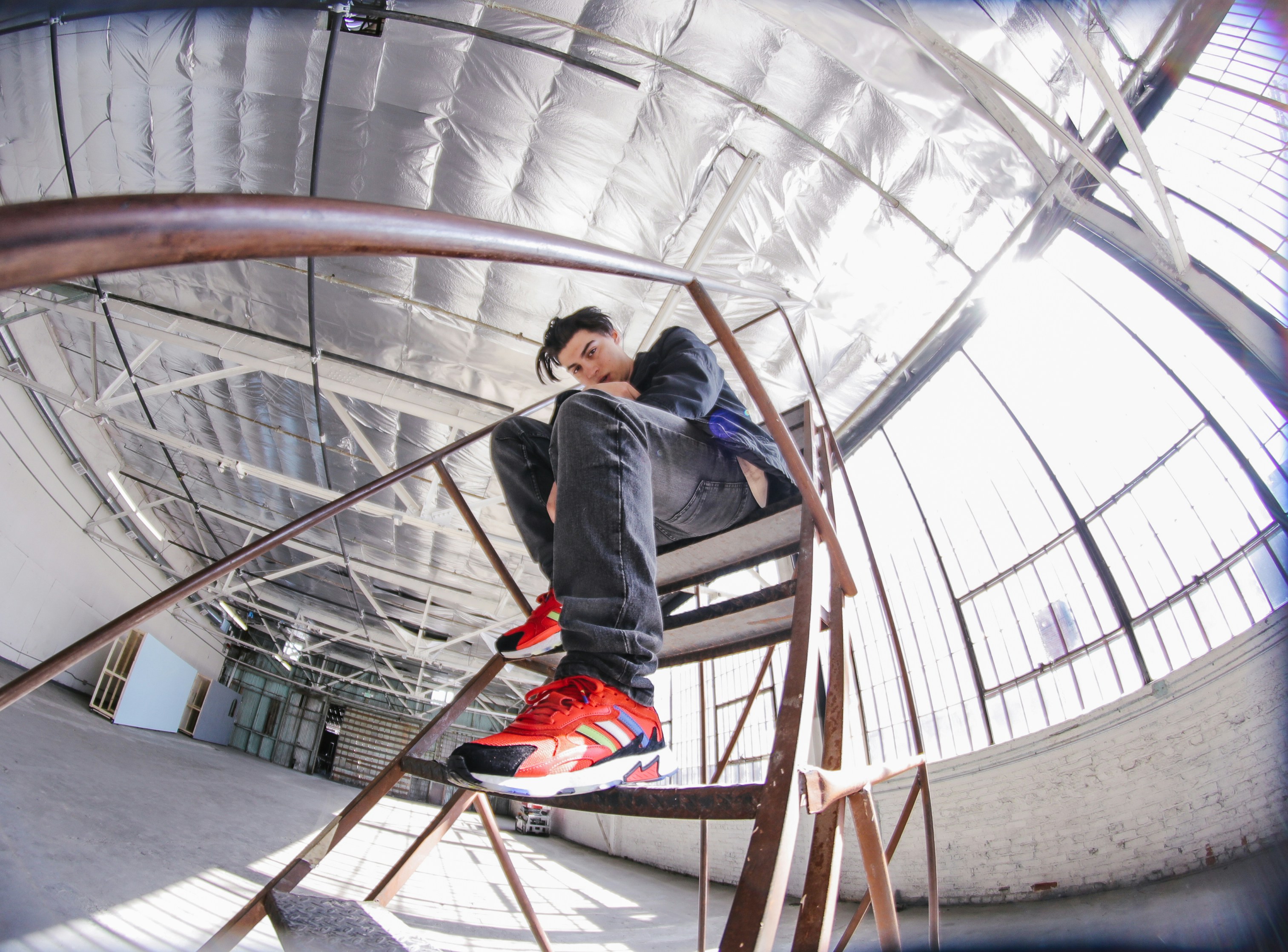 man sitting on brown metal portable stairs