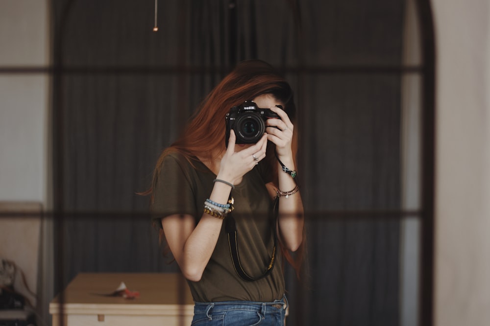 DSLR 카메라를 사용하여 사진을 찍는 여자