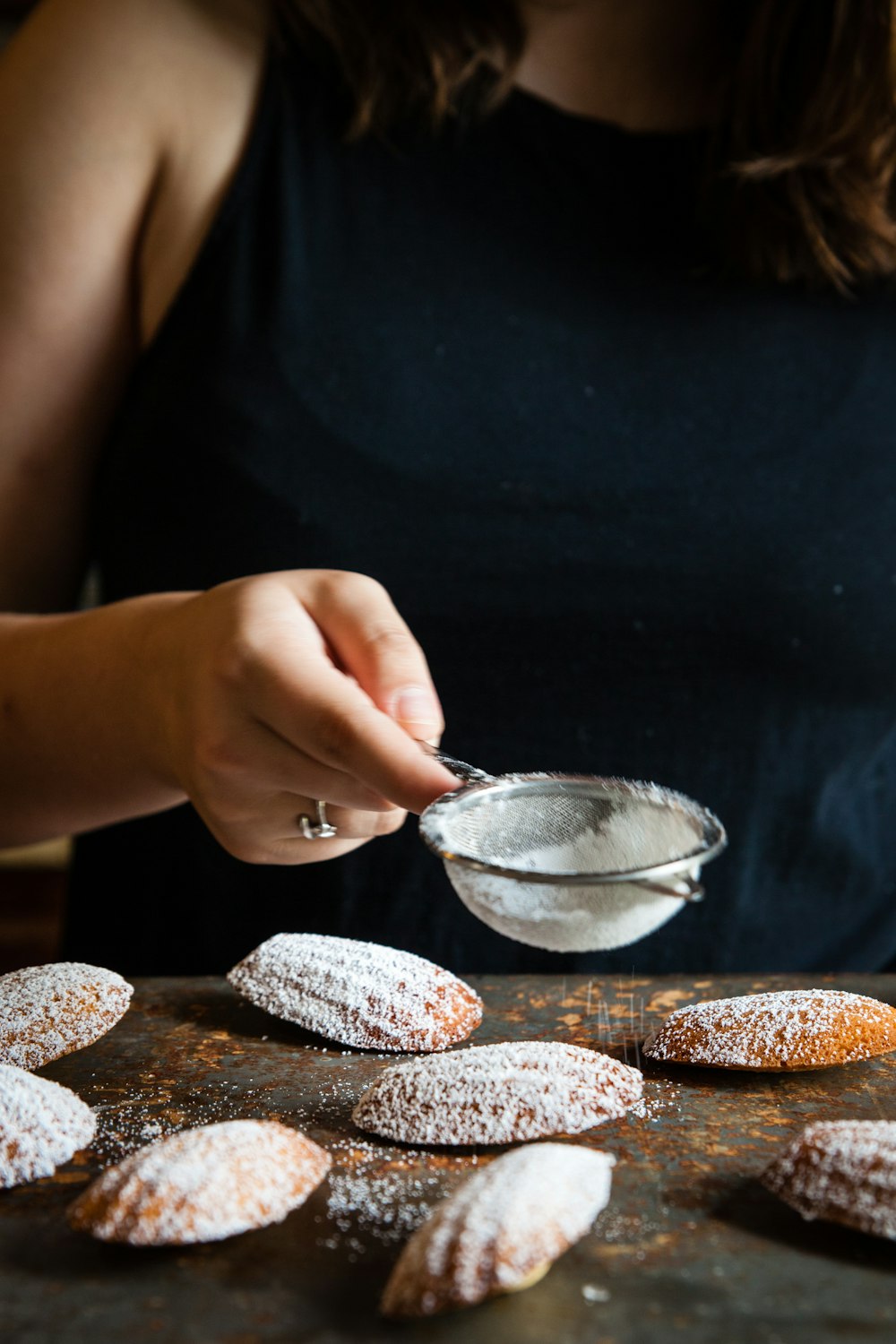 woman in black sifting flour