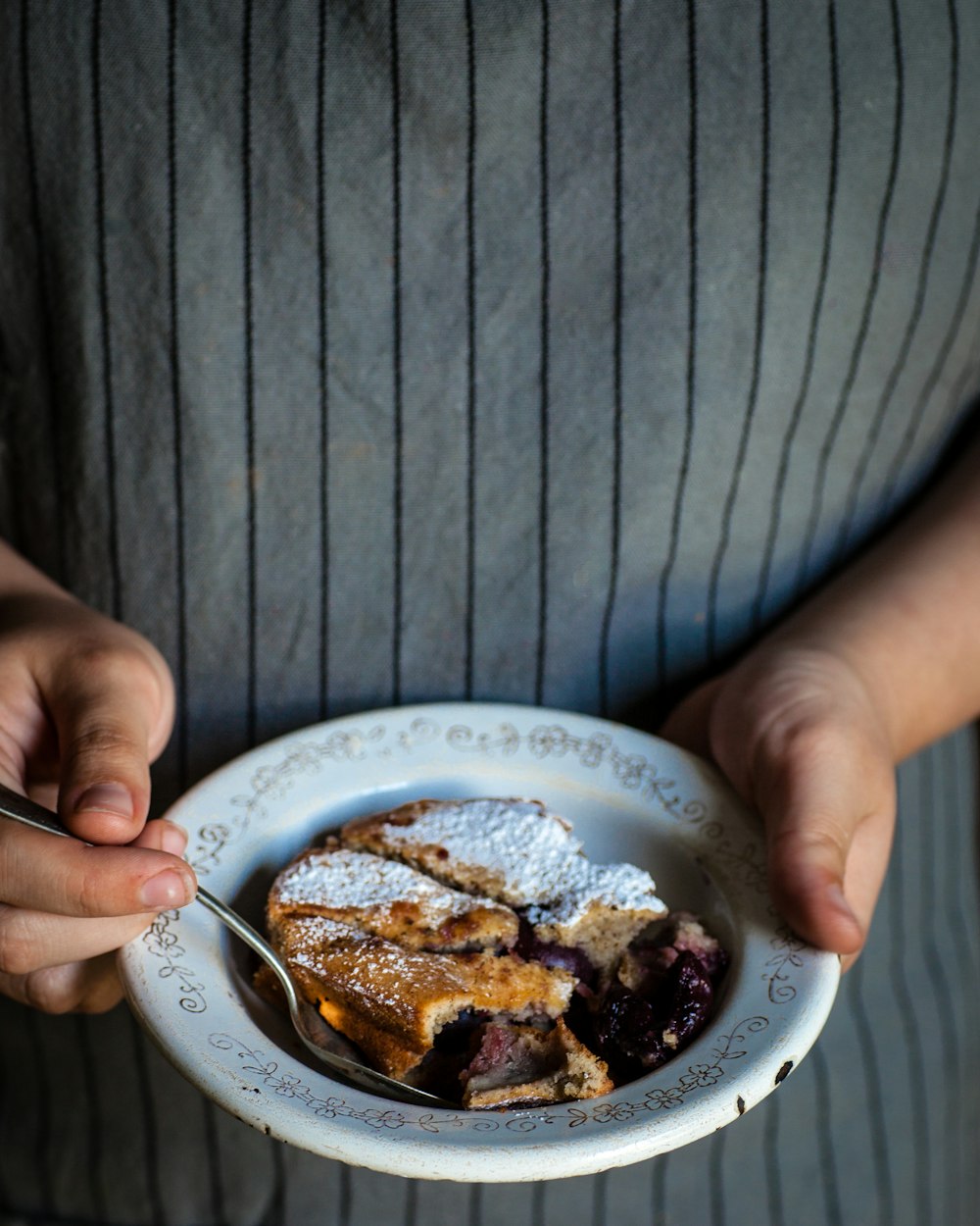 person holding plate with bread