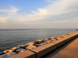 A peaceful seaside vacation scene with golden sunlight and clear blue skies.