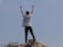 A happy person standing outdoors with arms raised, celebrating freedom from smoking.