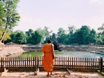 monk standing across body of water