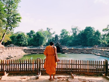 monk standing across body of water