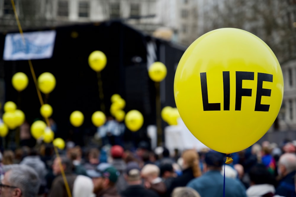 selektive Fokusfotografie des gelben Life-gedruckten Ballons