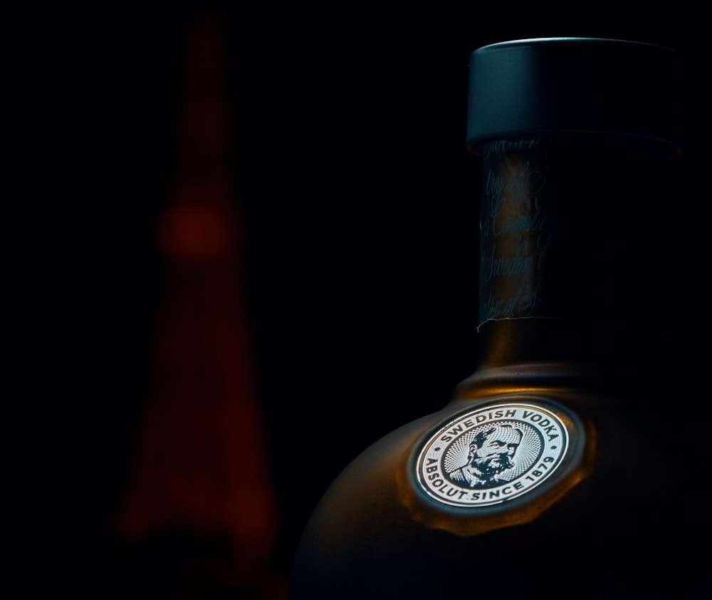 una bottiglia di liquore seduta al buio