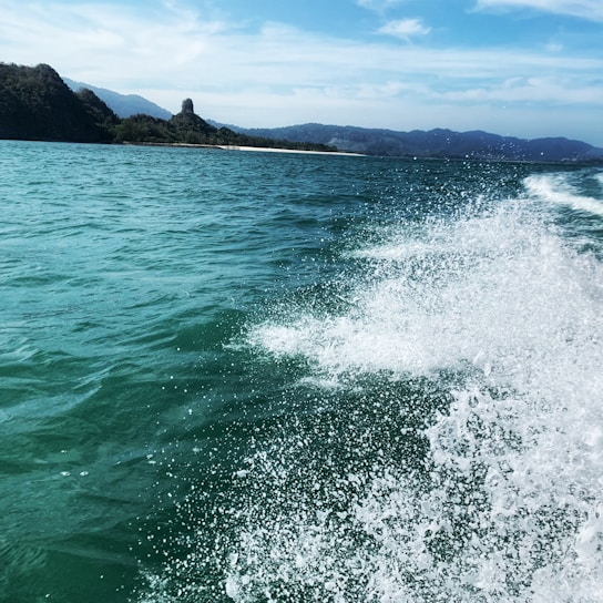 A scenic view of a fastboat cruising through turquoise waters near Bali.