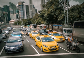 A busy city street with various transportation options including buses, taxis, and delivery vans.