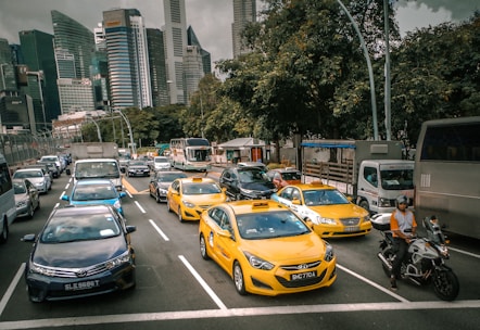 A busy city street with various transportation options including buses, taxis, and delivery vans.