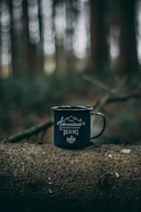 teal and white cup on brown tree log