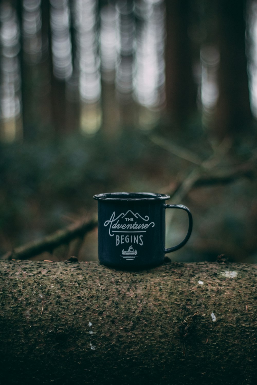 teal and white cup on brown tree log