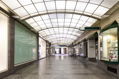 Inside a sleek, modern shopping arcade featuring polished floors and upscale storefronts.