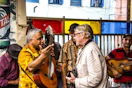 man talking with man holding guitar