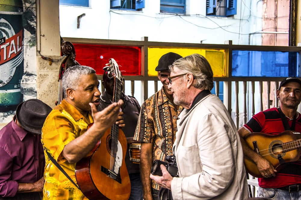 man talking with man holding guitar