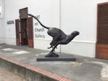 Sculpture of a running cheetah, frozen in dynamic motion with lifelike anatomy.
