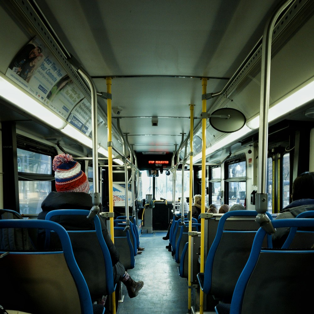 person in black jacket sitting on bus passenger chair