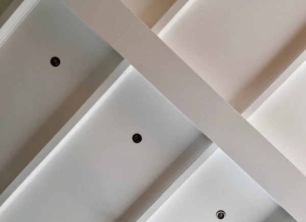 A freshly painted white ceiling seen from below in a bright room.