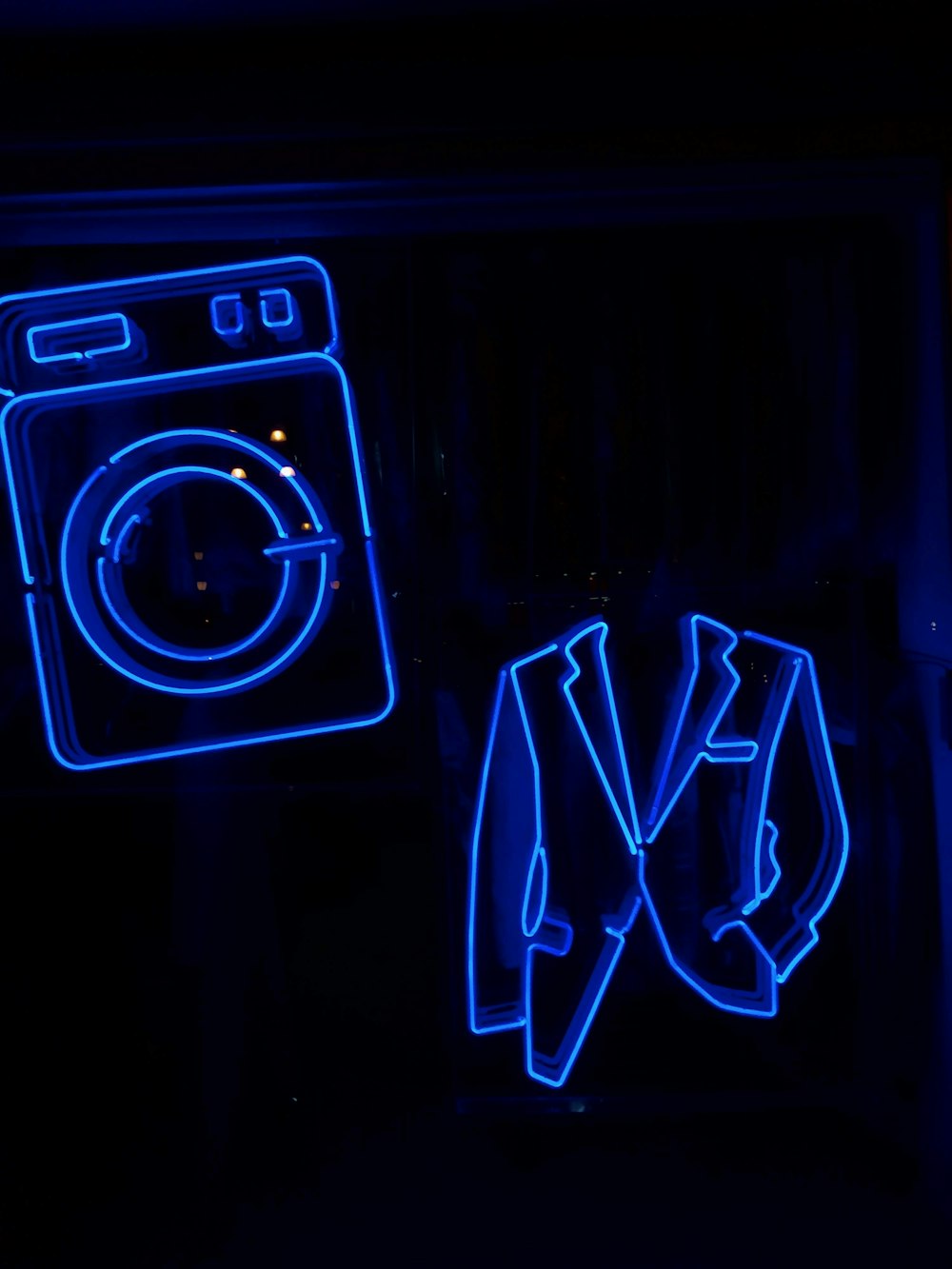 a washing machine in a dark room with blue neon lights