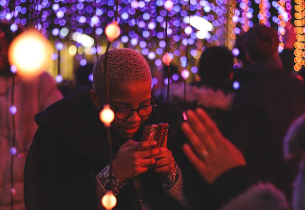 La mano de la persona a través de la persona que sostiene el teléfono inteligente