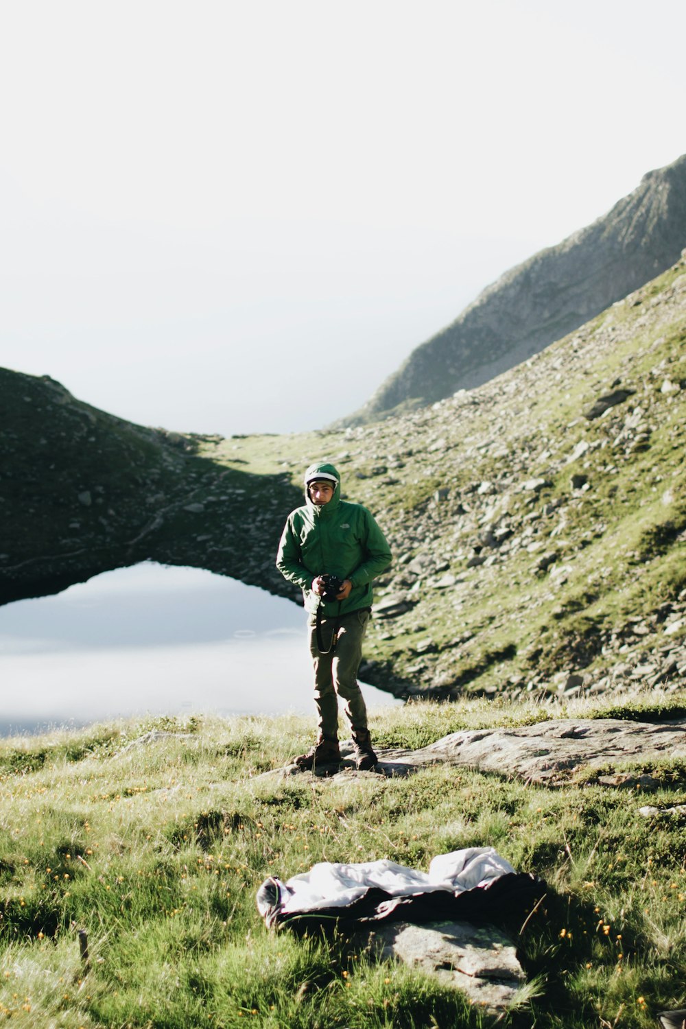 person wearing green hoodie across green hills