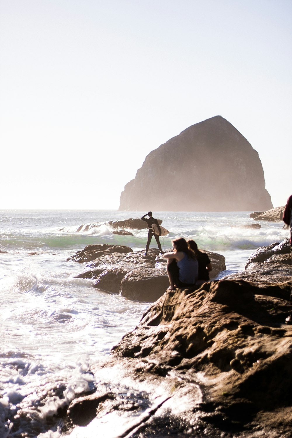 person standing on rock formation near ocean