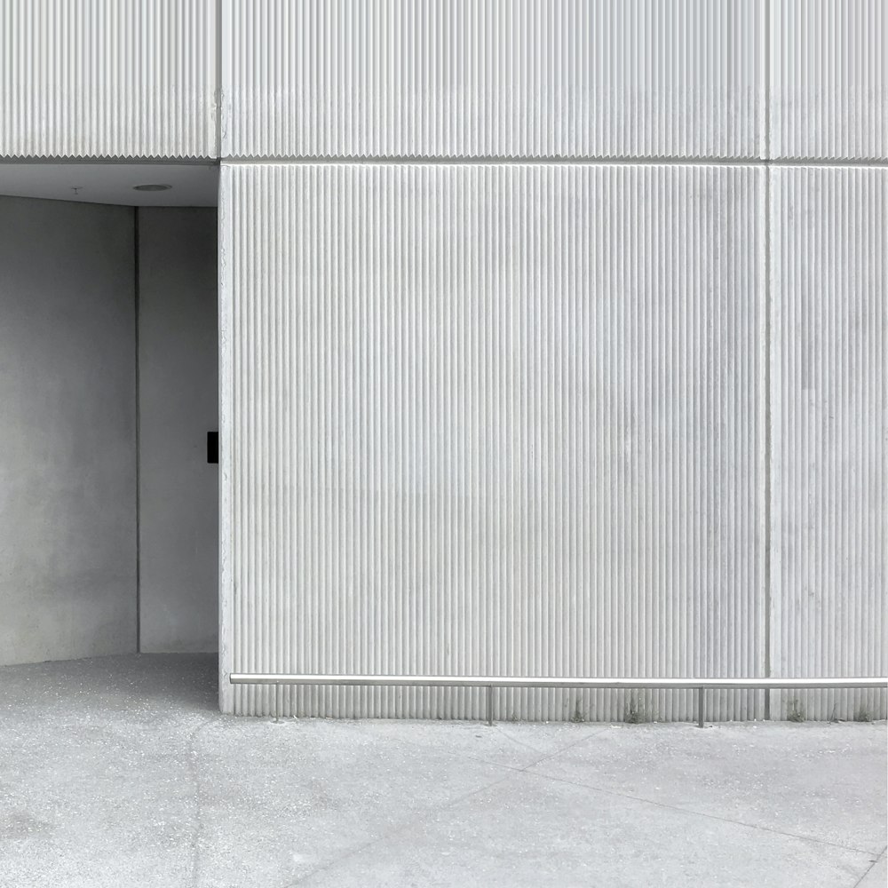 an empty room with a white wall and a black door