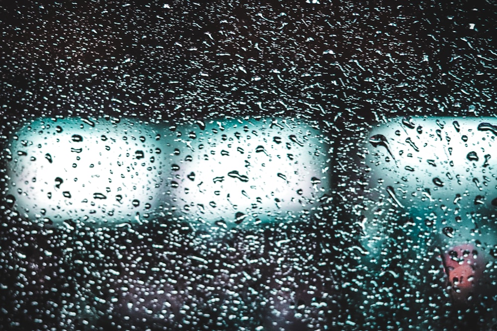 rain drops on a window with a traffic light in the background
