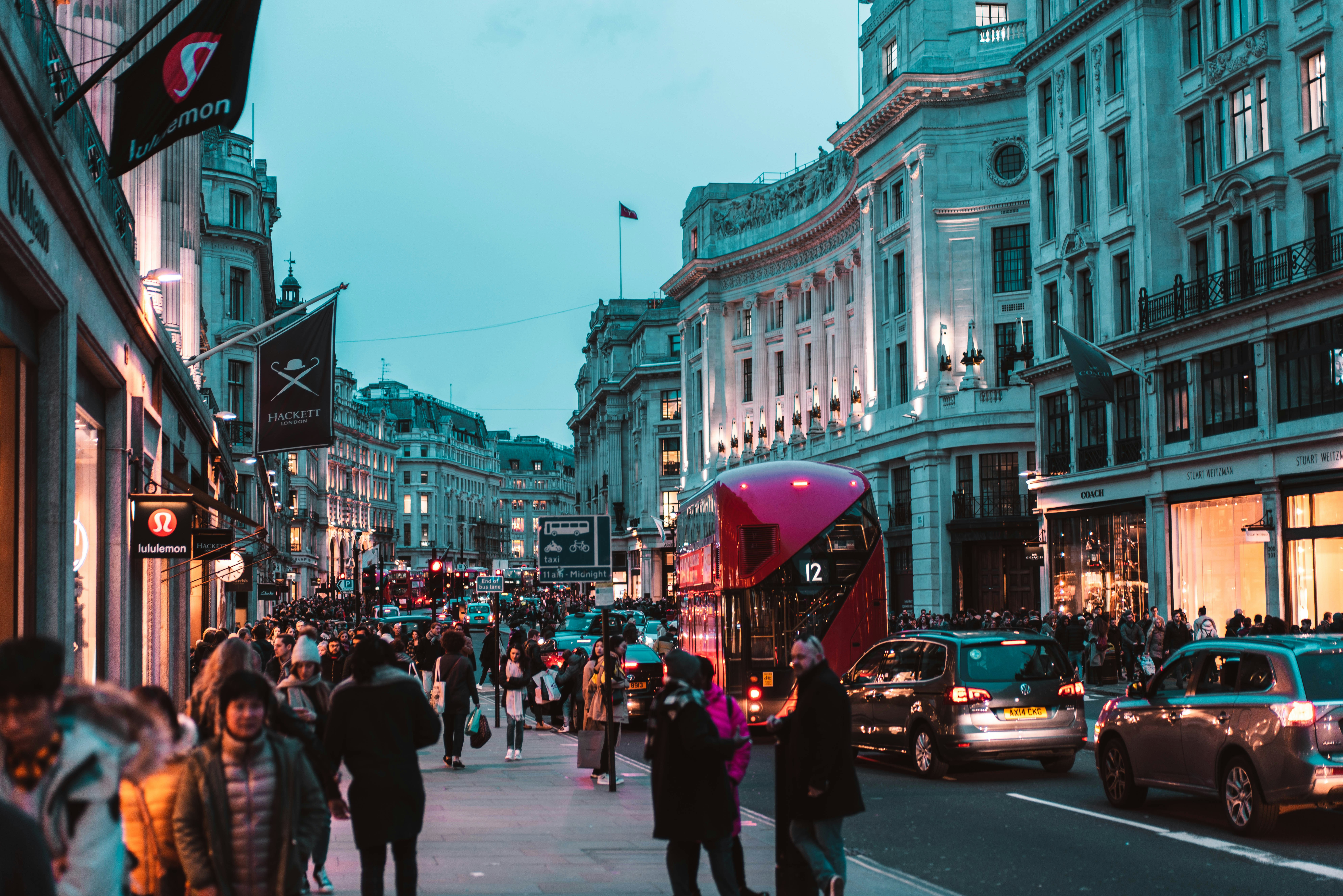 people on street beside white concrete building