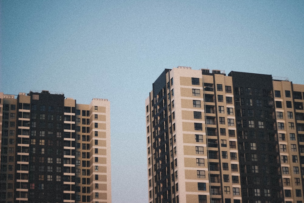 two gray-and-black concrete high-rise buildings