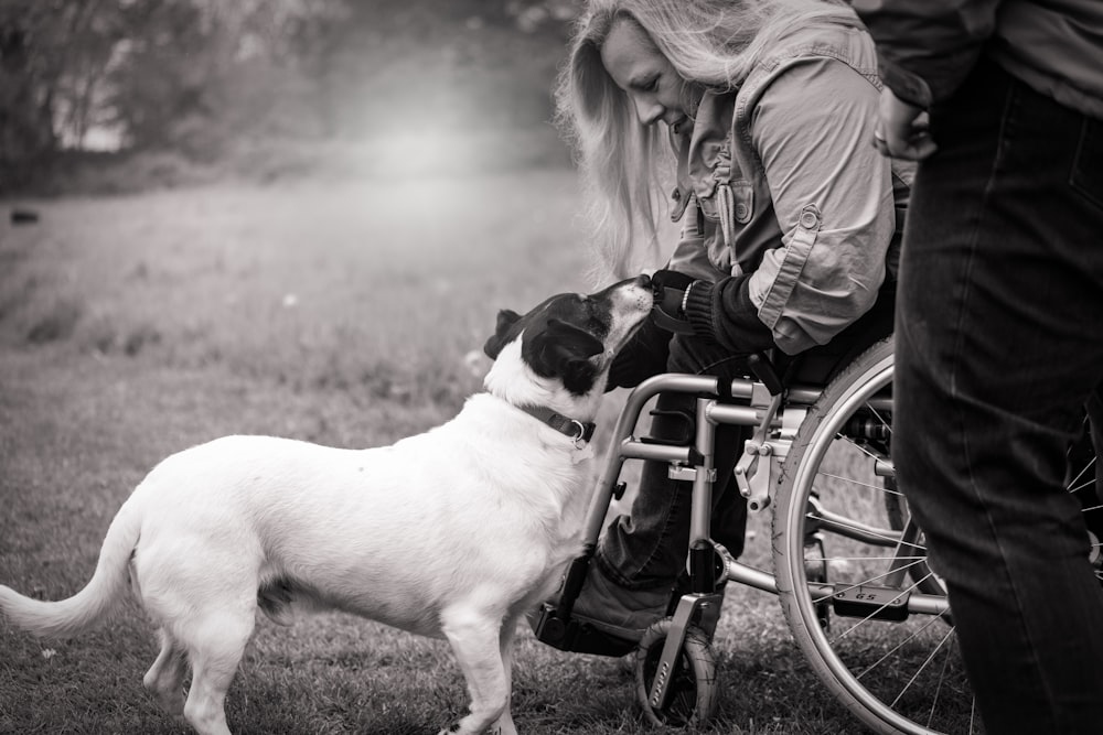 grayscale photo of woman holding dog