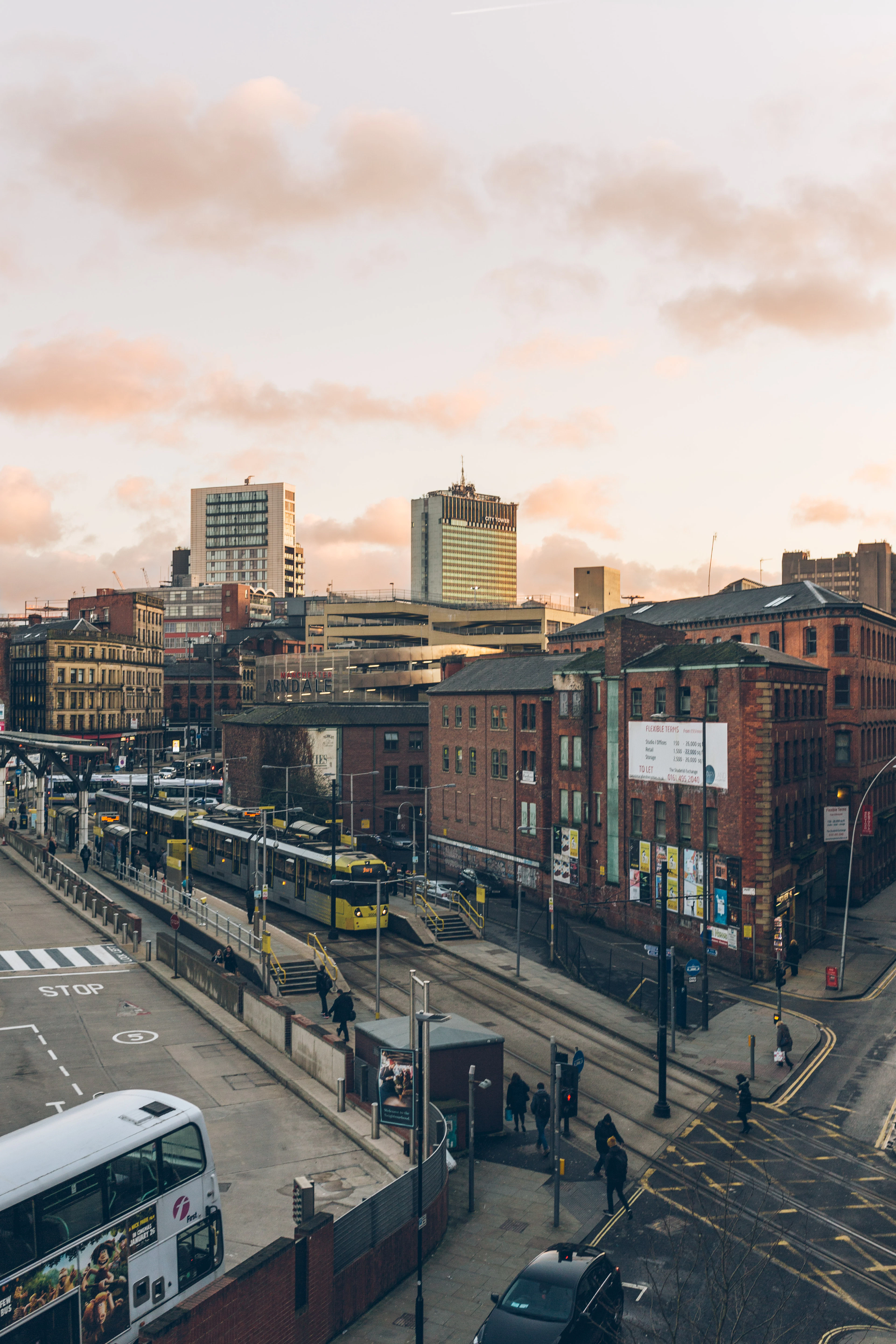 Manchester's brick warehouses and towers with a tram passing below