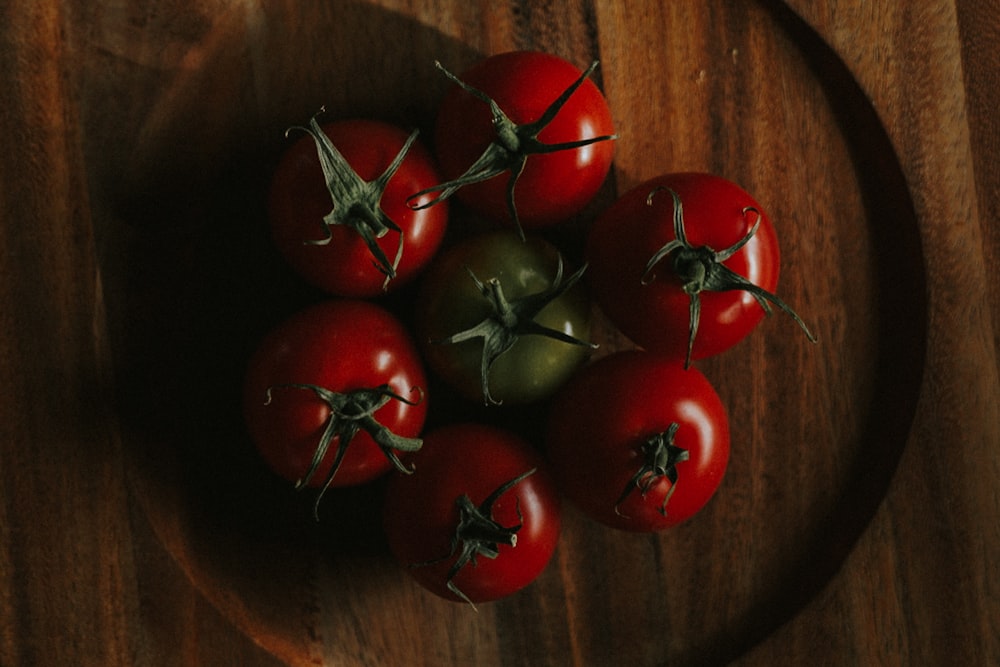 green tomato in the middle of red tomatoes