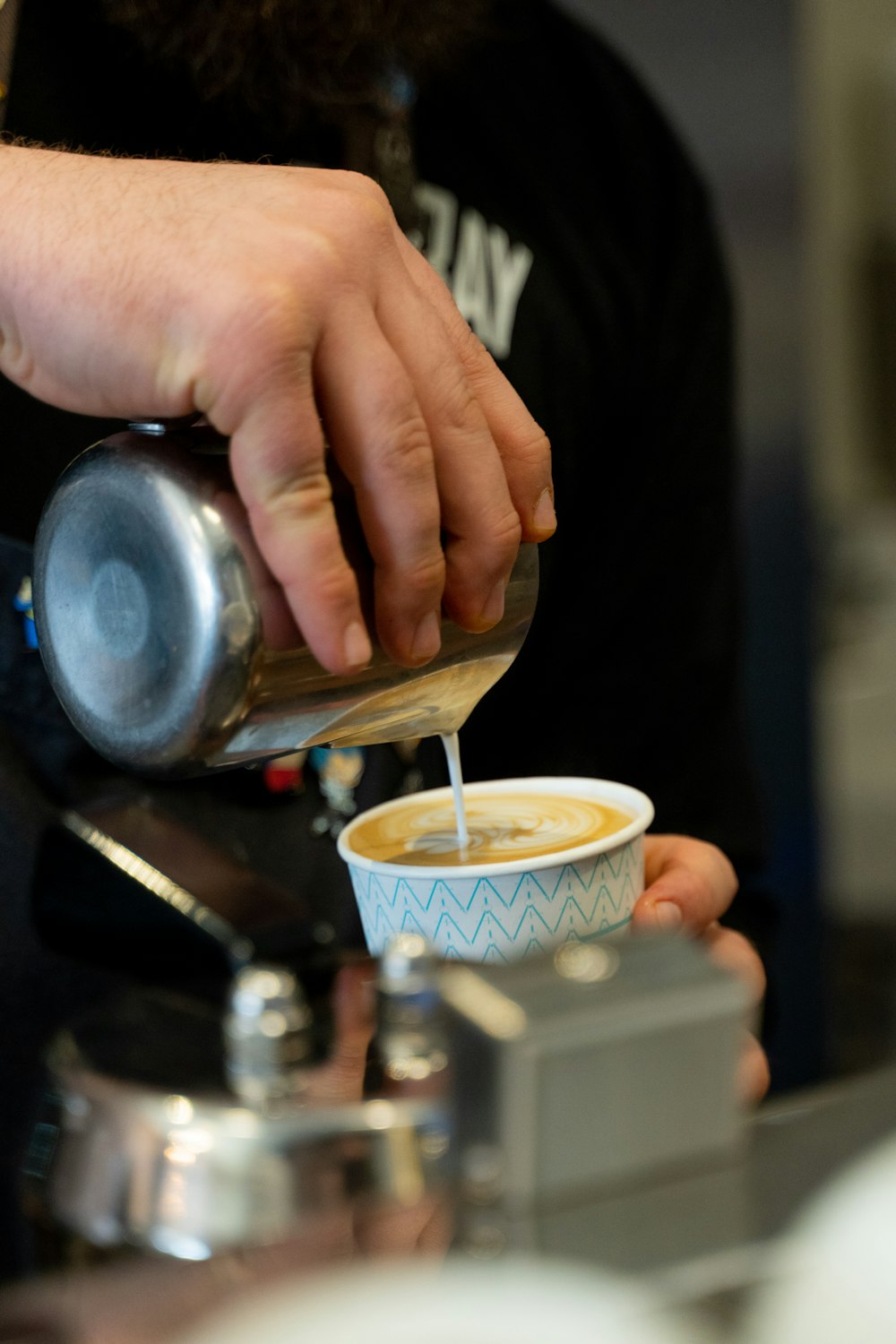 一杯のコーヒーをカップに注ぐ人