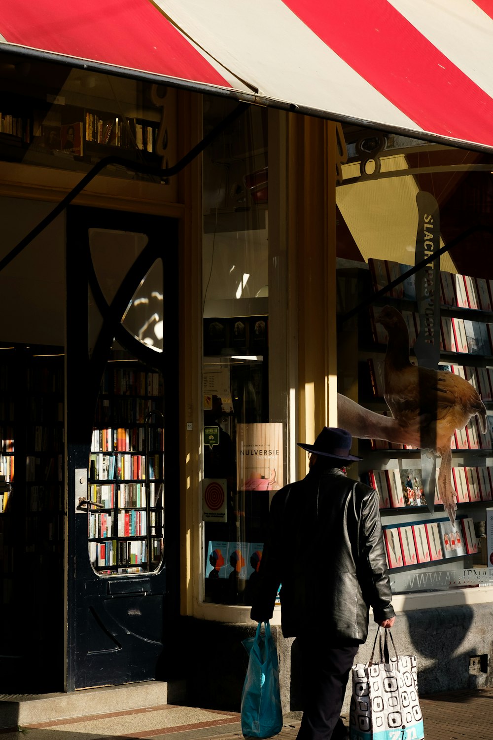 man standing beside store facade