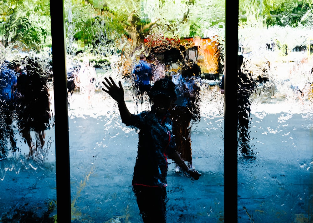 boy standing in front of glass panel